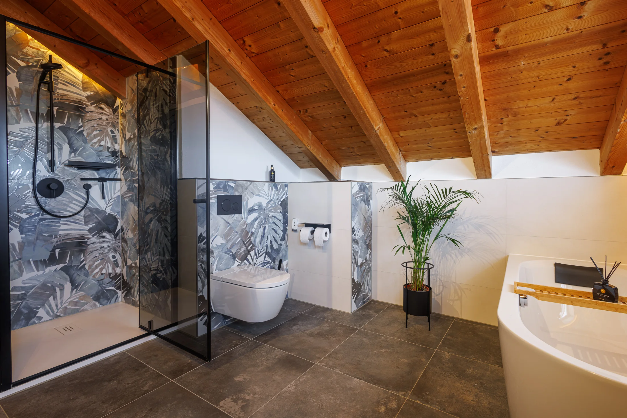 Bad unter einer Holzdecke mit bodengleicher Dusche hinter Glas, Blattmuster-Fliesen und Eckbadewanne